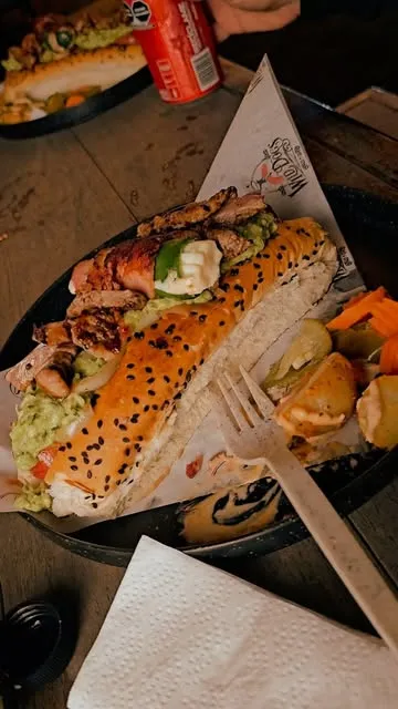 Hot dog cargado con pollo a la plancha, guacamole y crema